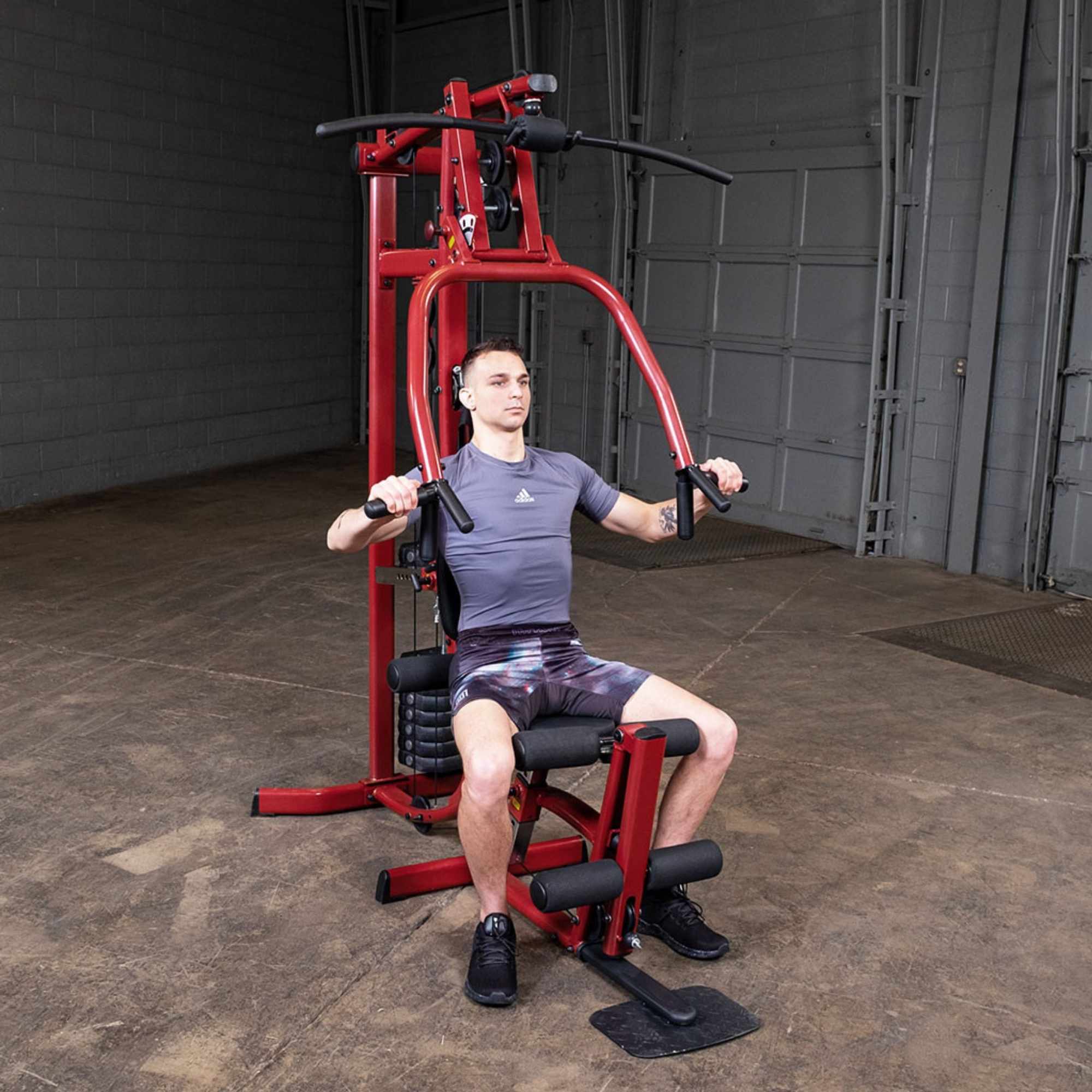 Body-Solid Best Fitness Multi-Station Gym BFMG30 Man performing chest press on red Body-Solid home gym system