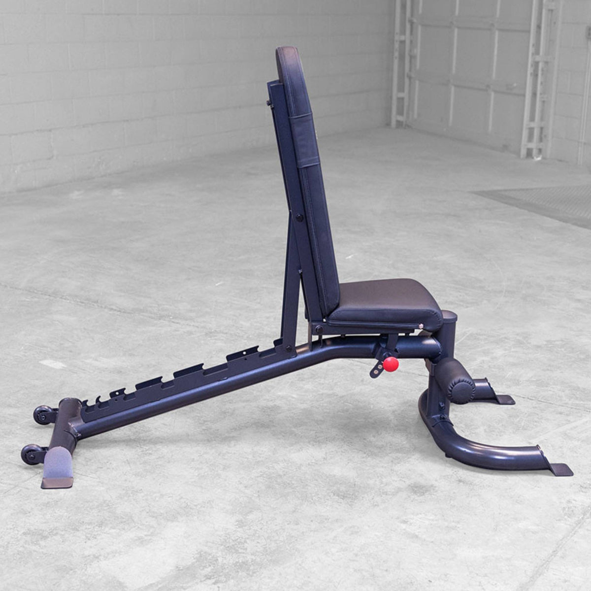 Body-Solid Flat Incline Decline Bench GFID100B Upright position of an adjustable weight bench on a concrete floor