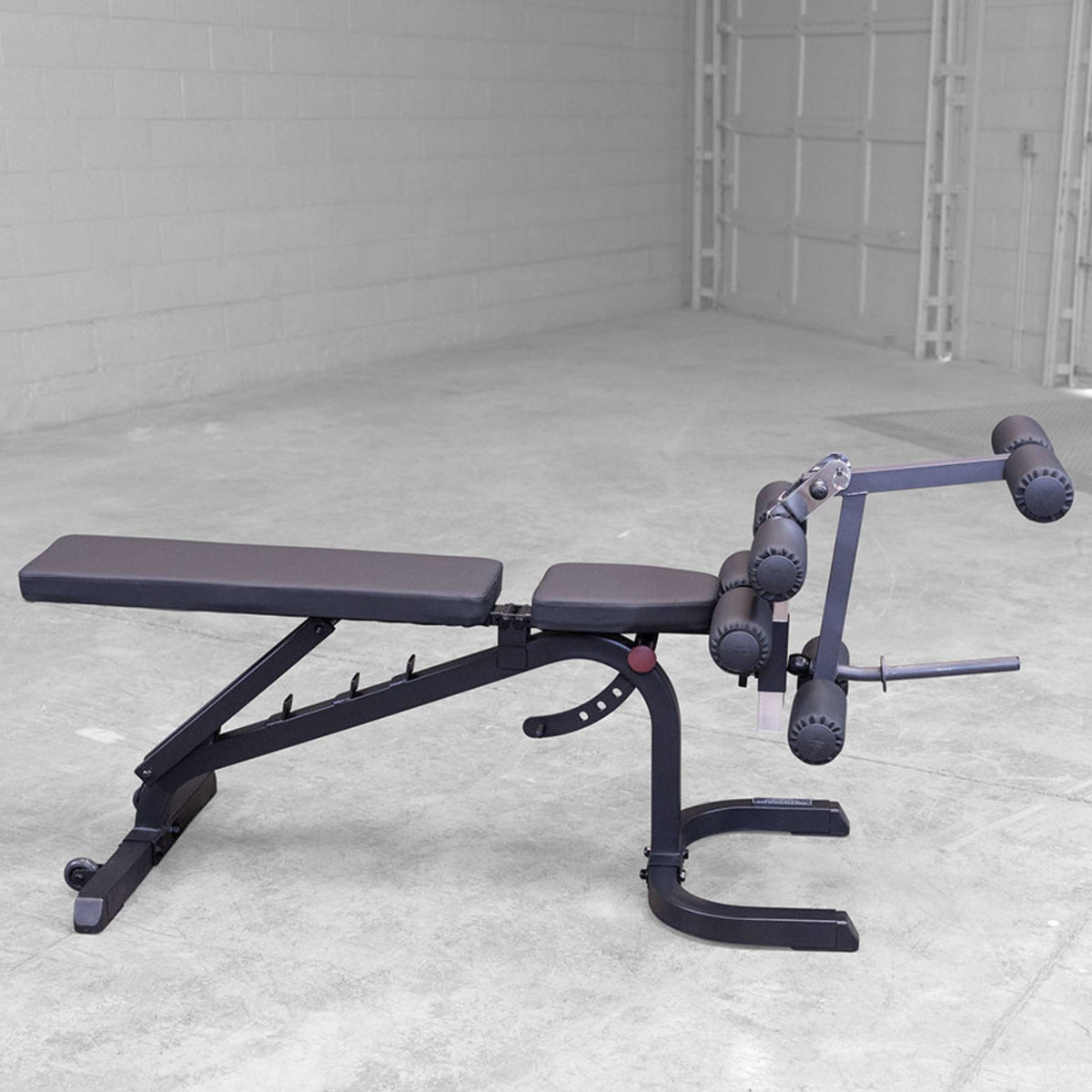 Body-Solid Flat Incline Decline Bench GFID31 Close-up of a Body-Solid weight bench showing the leg developer attachment setup