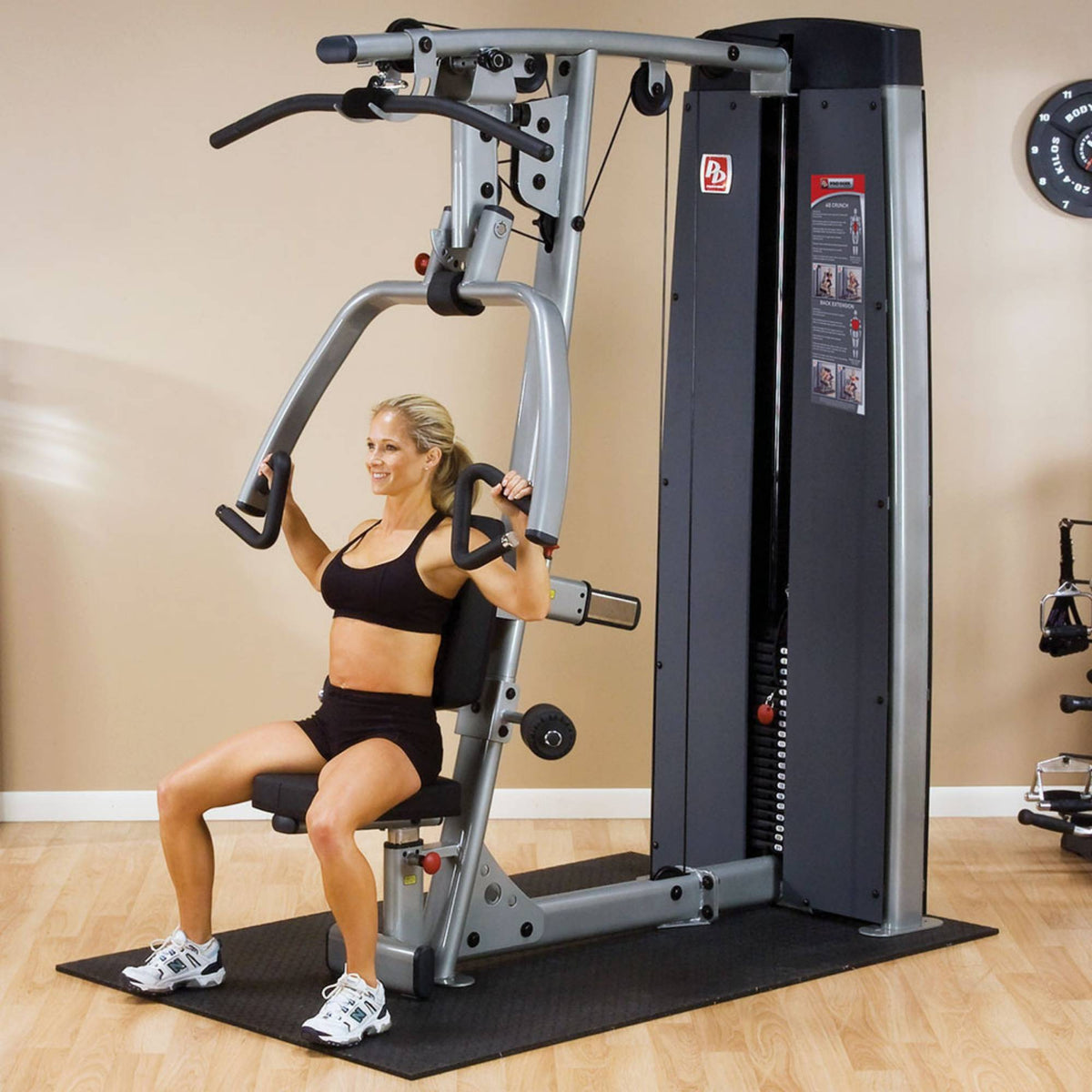 Body-Solid ProDual Press Arm Lat Machine With Weight Stack DPLSSF Woman performing chest press on vertical press station