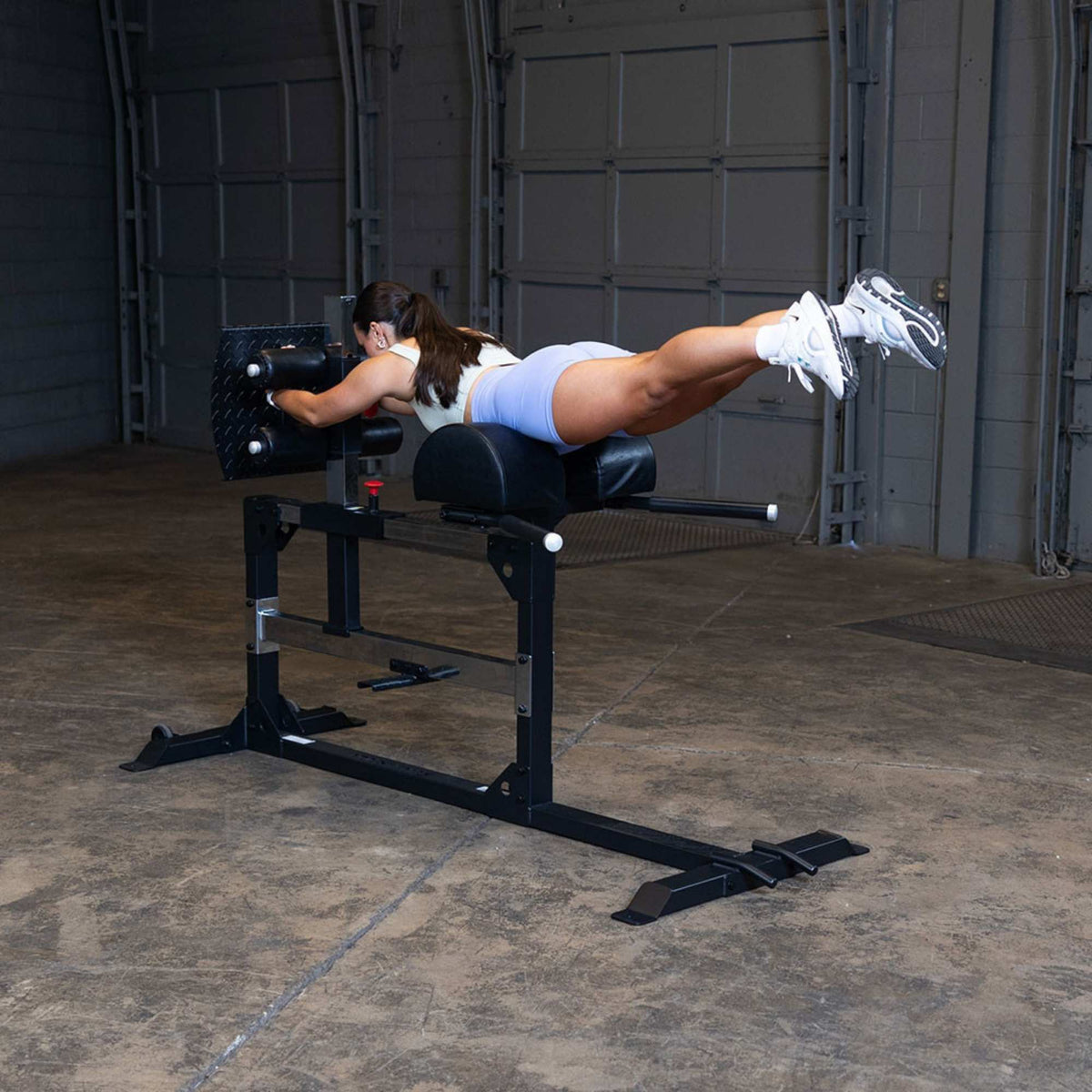 Body-Solid Pro ClubLine Glute Ham Machine SGH500B Woman doing back extensions on GHD