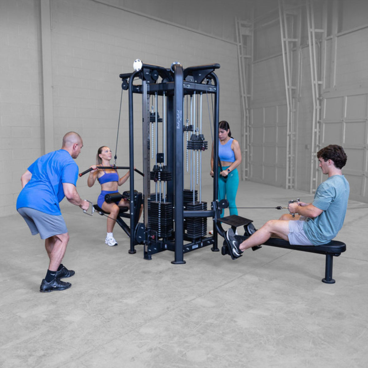 Body-Solid Pro ClubLine SJG Jungle Gym SJG100 Group of people performing seated rows and lat pulldowns on a Body-Solid Pro Club Line multi-station gym machine.