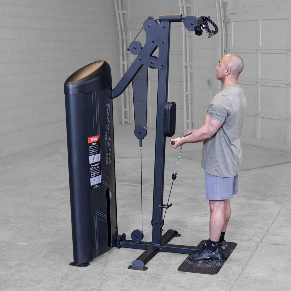 Body-Solid Pro ClubLine Series 2 Biceps Triceps S2BTPX Side view of man holding a cable bar while performing a controlled bicep curl on a black cable pulley machine.