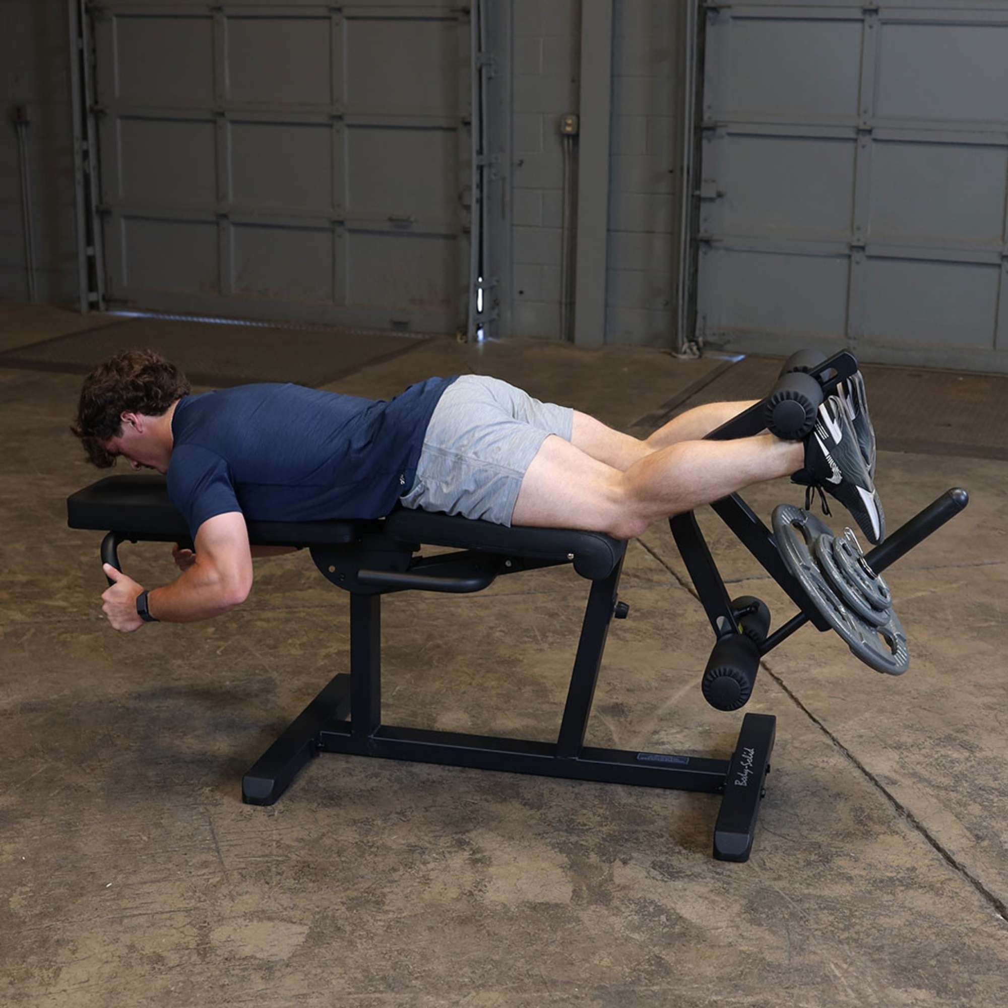 Body-Solid Seated Leg Extension & Supine Curl GLCE365B Prone leg curl position mid-rep using Body-Solid machine