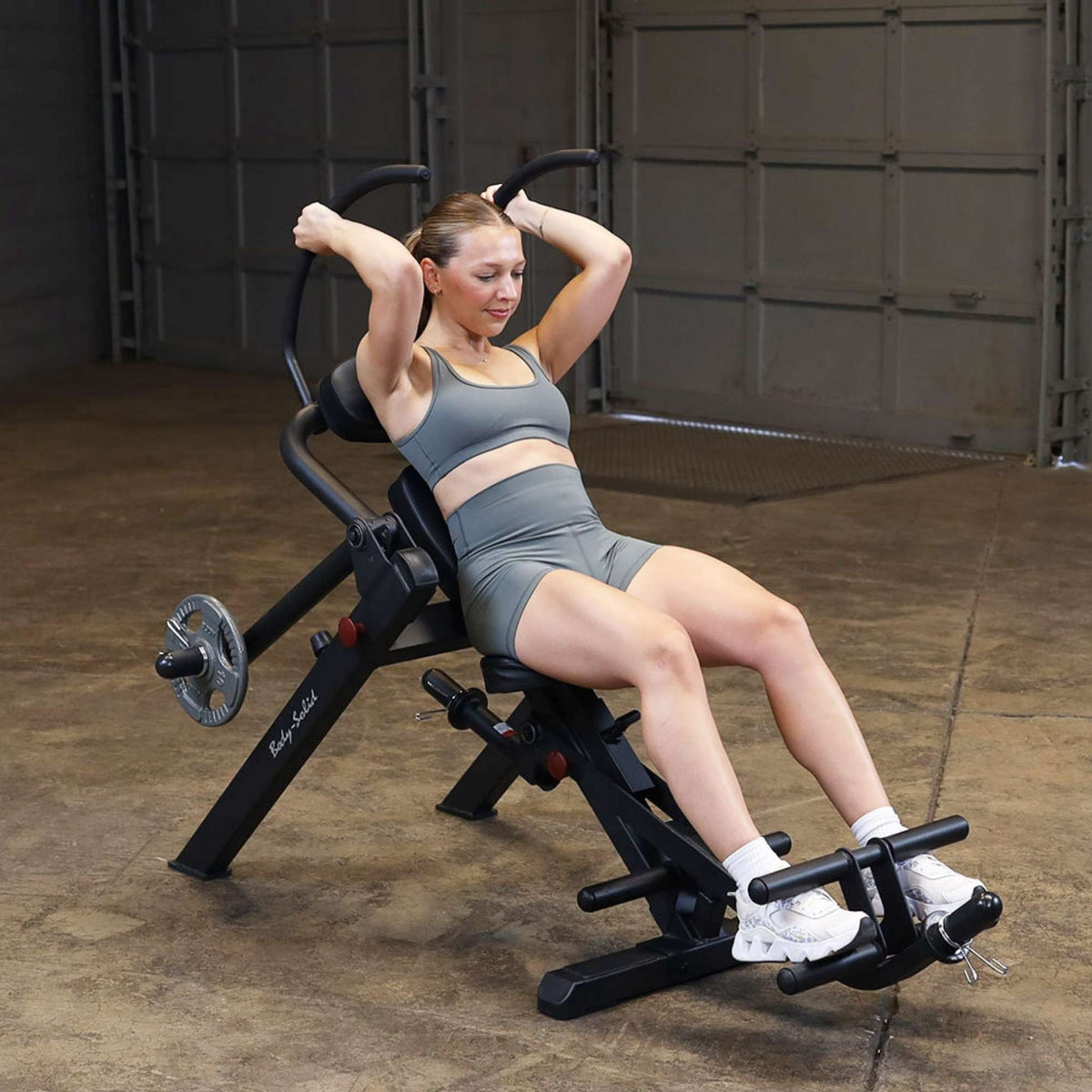 Body-Solid Semi-Recumbent Ab Bench GAB300B Woman performing a weighted abdominal crunch