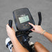 Best Fitness Recumbent Bike BFRB1B Close-up view of a person using the Best Fitness RB1 recumbent bike console, adjusting workout settings on the digital display.