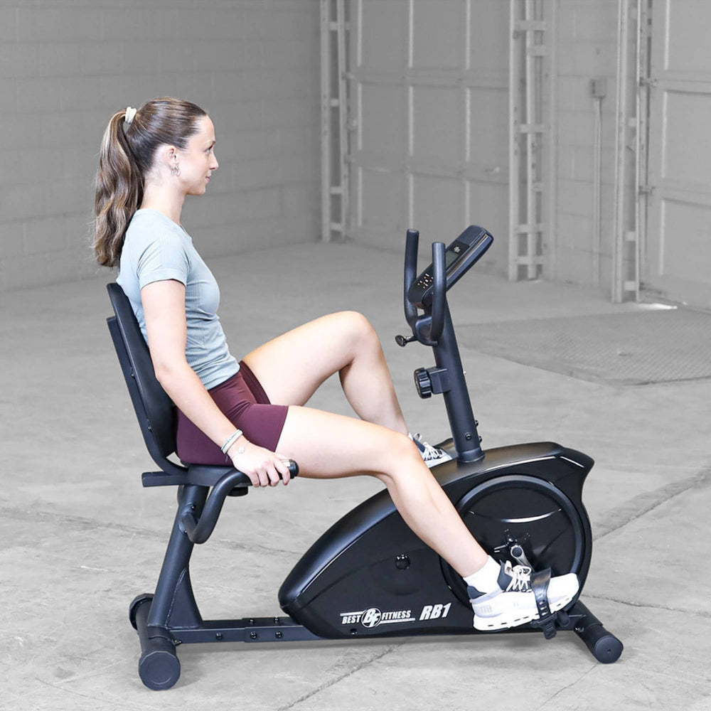 Best Fitness Recumbent Bike BFRB1B Female athlete performing steady-state cardio on Best Fitness RB1 recumbent bike in an open studio space.
