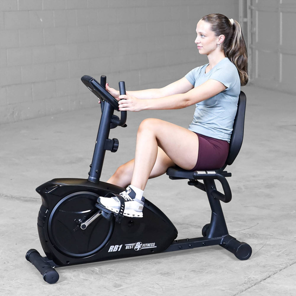 Best Fitness Recumbent Bike BFRB1B Side view of woman exercising on Best Fitness RB1 recumbent bike, demonstrating ergonomic back support.