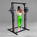 Best Fitness Smith Machine BFSM250B Back view of woman holding barbell at shoulder height inside Body-Solid Smith machine frame