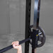 Best Fitness Smith Machine BFSM250B Close-up of weight plate and safety hook attachment on Body-Solid Smith machine during lift.
