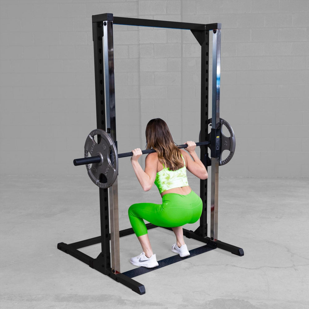 Best Fitness Smith Machine BFSM250B Woman performing deep squat using Body-Solid Smith machine with barbell and weight plates.