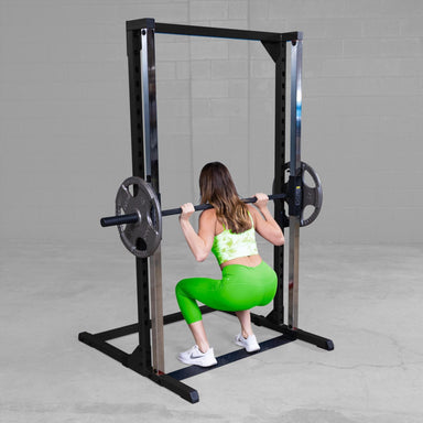 Best Fitness Smith Machine BFSM250B Woman performing deep squat using Body-Solid Smith machine with barbell and weight plates.