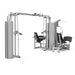 A BodyKore multi-function cable and leg extension gym machine in silver steel with black padded seats and handles, shown on a solid white background.