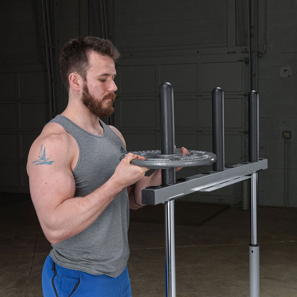 Man adjusting a Body-Solid 14" Olympic Adapter Sleeve OAS14