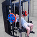 A man performing a bench press on a Body-Solid-GSFR-100All-in-OneFunctional-Trainer-Smith-Machine with red and blue weight plates in a gym setting.
