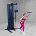 Body-Solid-S2CC-Series-2-Cable-Column-Single-Arm-Cable-Front-Punch. Woman exercising on a cable machine in a gym setting