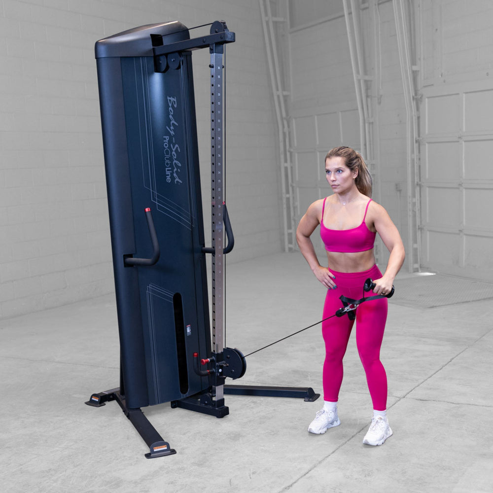 Body-Solid-S2CC-Series-2-Cable-Column-Single-Arm-Cable-Front-Raise. Woman exercising with a cable machine in a gym setting