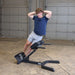 Body-Solid 45 Back Hyperextension GHYP345B Man performing side bend exercise on  hyperextension bench in a gym
