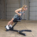 Body-Solid 45 Back Hyperextension GHYP345B Woman doing weighted hyperextension