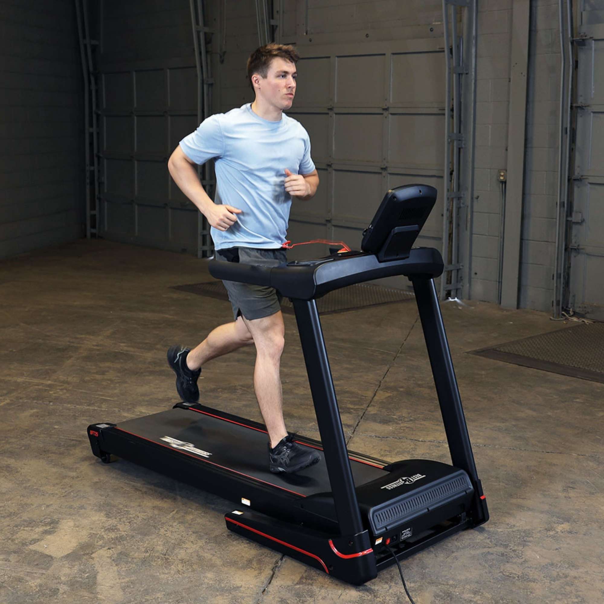 Body-Solid Best Fitness Folding Treadmill With LED Console BFT25 Man running on Best Fitness treadmill for home fitness workouts