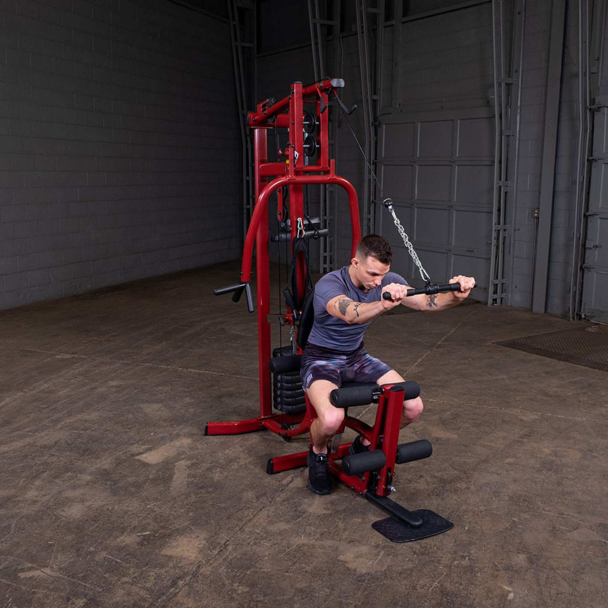 Body-Solid Best Fitness Multi-Station Gym BFMG30 Man using red Body-Solid home gym for ab crunch workout