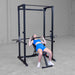 Body-Solid Best Fitness Power Rack BFPR100B Woman lying on adjustable bench performing an incline bench press inside a power rack.
