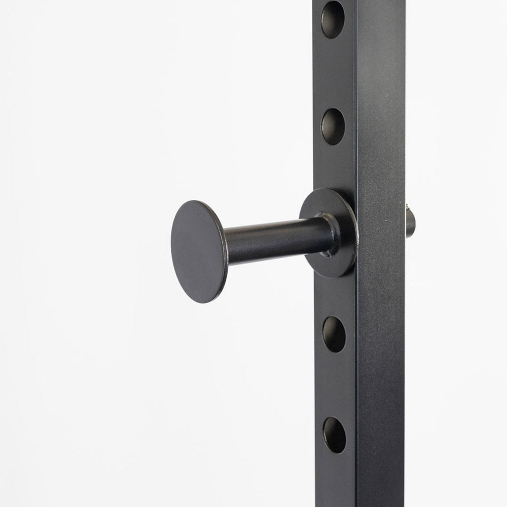 Body-Solid Best Fitness Power Rack BFPR100B Close-up view of power rack safety peg inserted into steel frame adjustment holes for barbell support.
