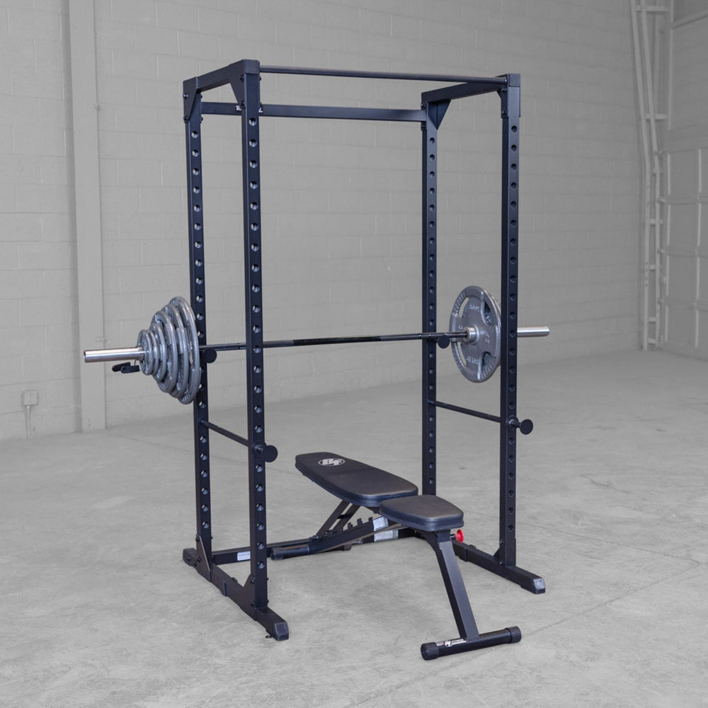 Body-Solid Best Fitness Power Rack BFPR100B Power rack with adjustable bench and loaded barbell, ideal for full-body strength training.
