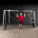 Body-Solid Cable Crossover GDCC250B Man doing shoulder press on  functional cable crossover system