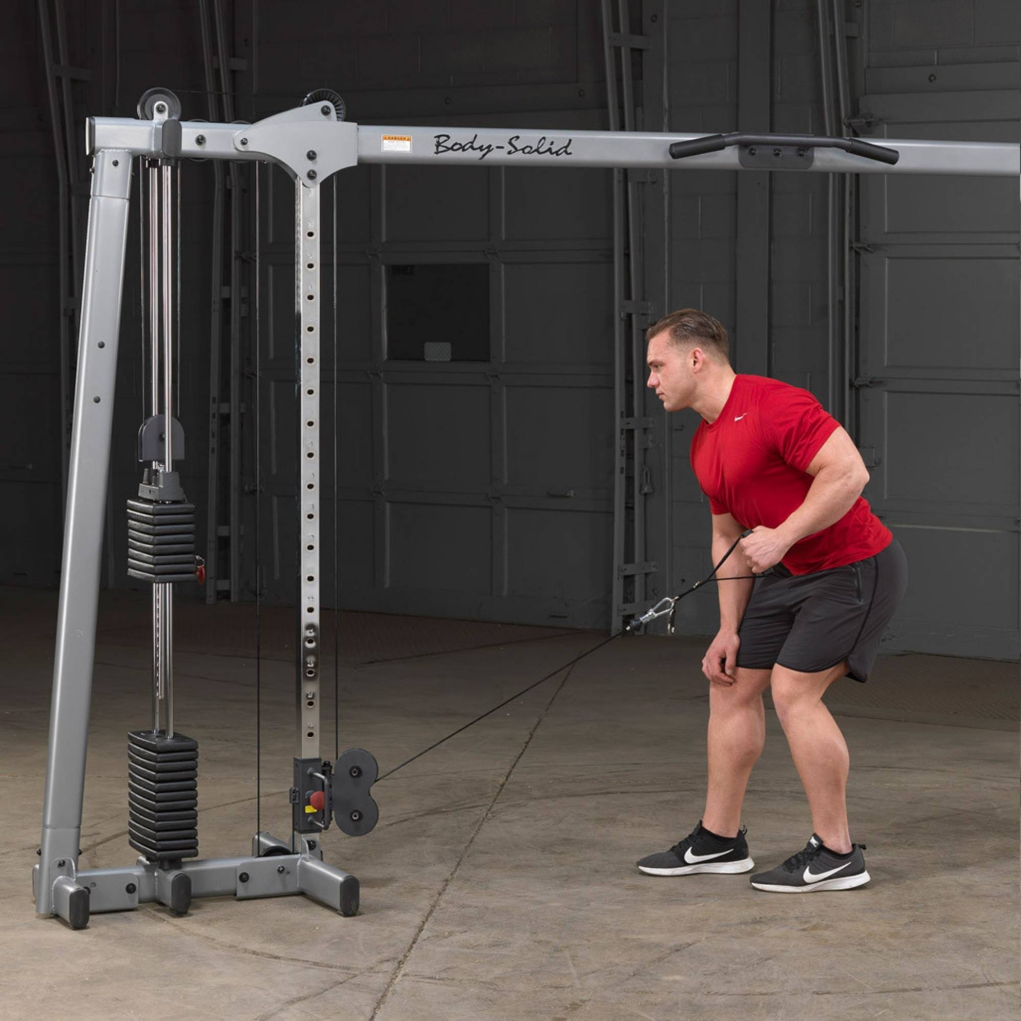Body-Solid Cable Crossover GDCC250B Man performing one-arm bent-over row using