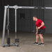 Body-Solid Cable Crossover GDCC250B Man performing one-arm bent-over row using