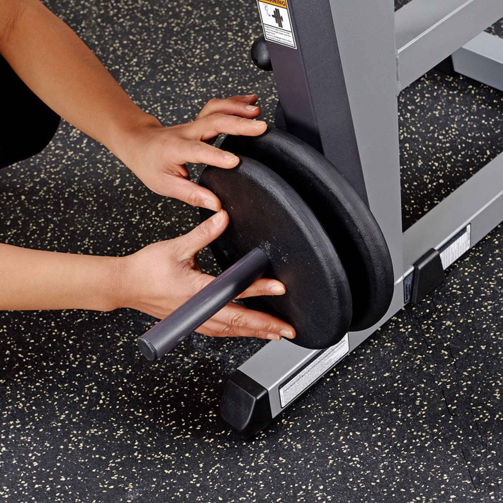 Body-Solid Cam Series Ab & Back Machine GCAB360B Close-up of hands loading weight plates onto the Body-Solid abdominal crunch machine