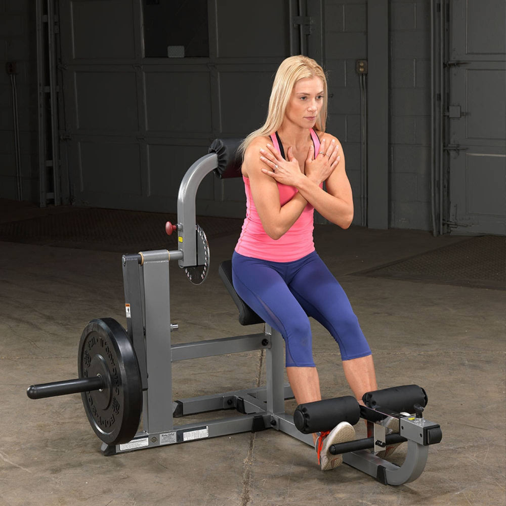 Body-Solid Cam Series Ab & Back Machine GCAB360B Woman in upright position preparing to perform an ab crunch on the Body-Solid plate-loaded machine.