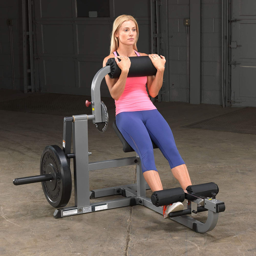 Body-Solid Cam Series Ab & Back Machine GCAB360B Woman performing a seated abdominal crunch on a Body-Solid plate-loaded ab machine with weighted resistance