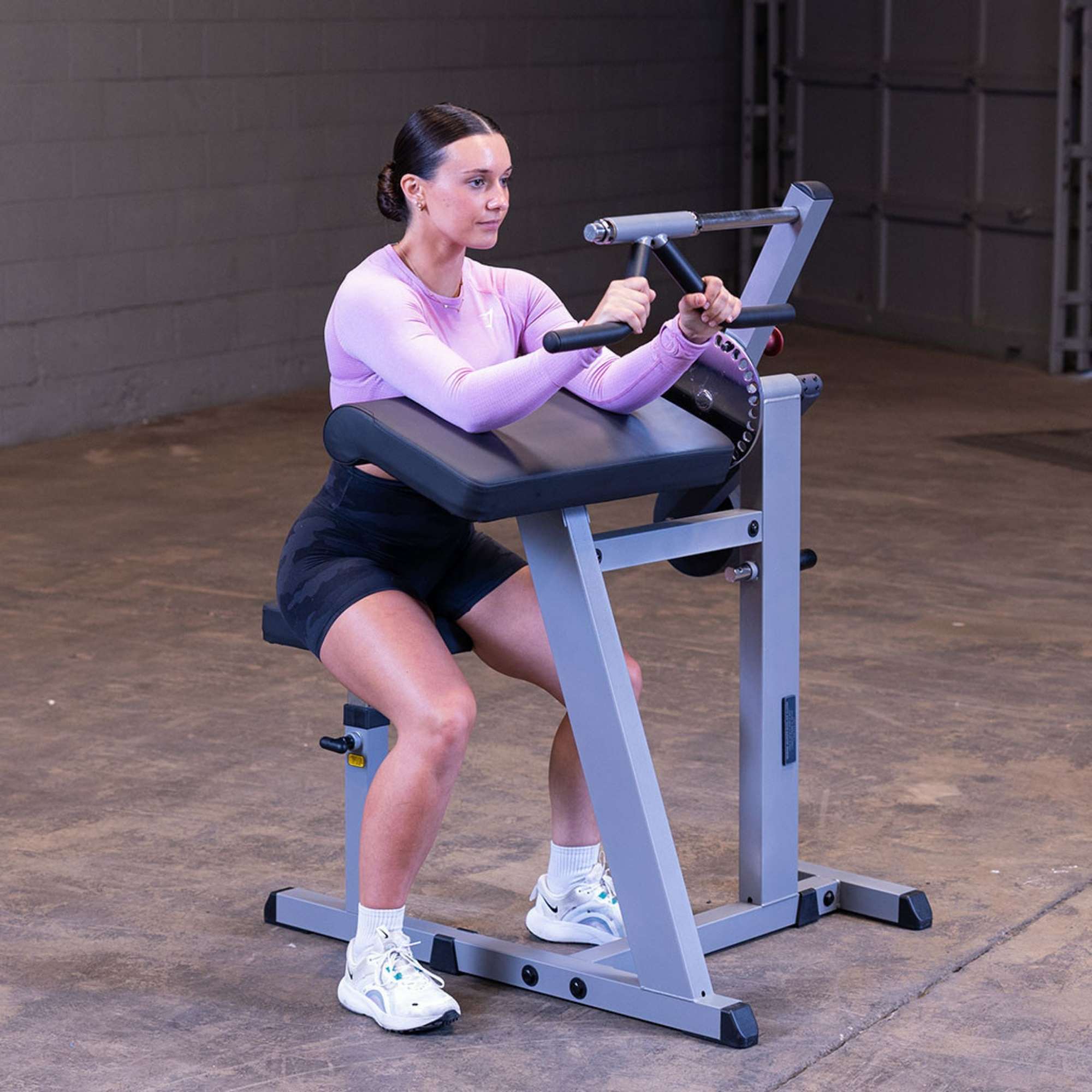 Body-Solid Cam Series Biceps & Triceps GCBT380B Female user performing bicep curls 