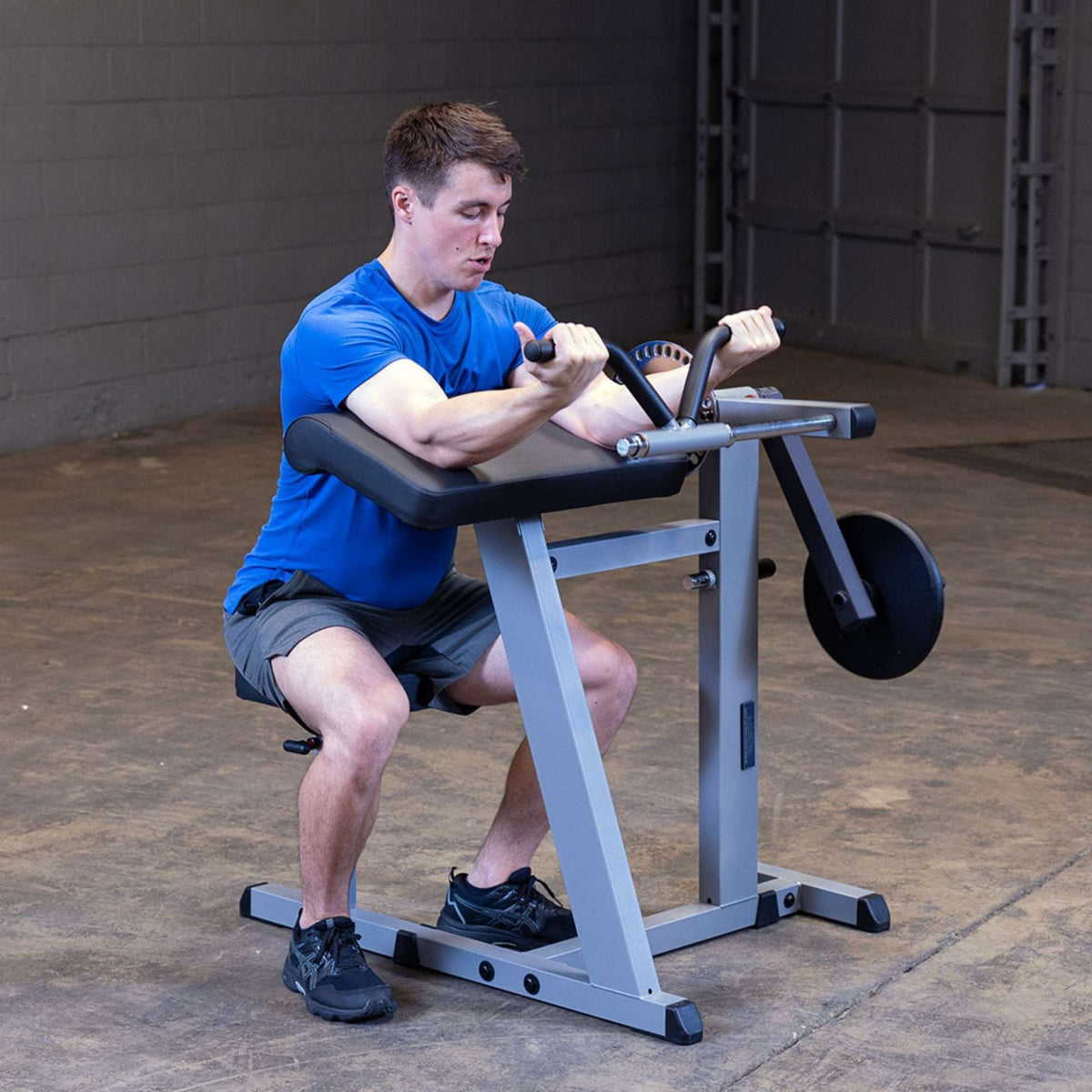 Body-Solid Cam Series Biceps & Triceps GCBT380B Male user mid-rep on preacher curl bench showing elbow positioning