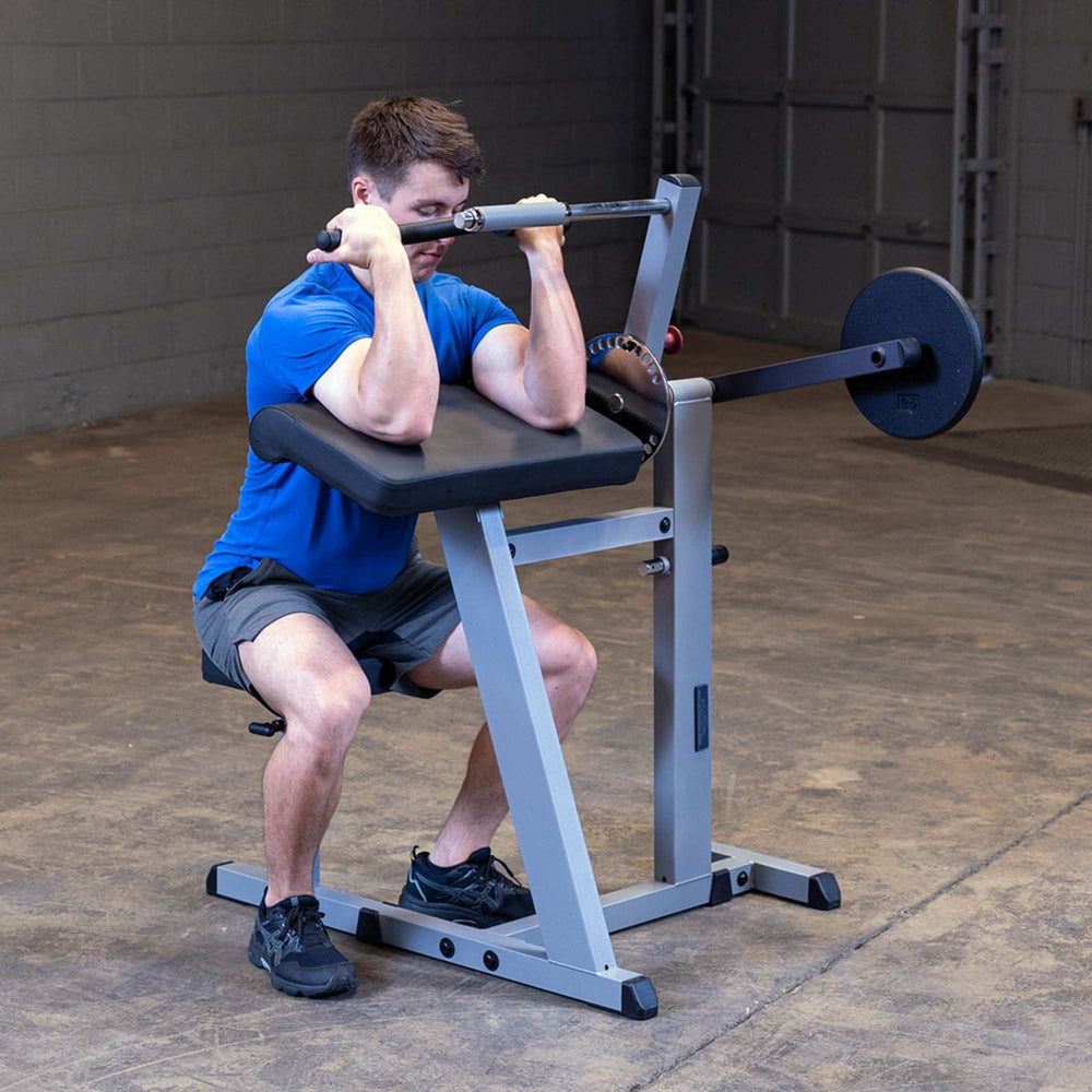 Body-Solid Cam Series Biceps & Triceps GCBT380B Man completing curl motion with full contraction on preacher curl machine