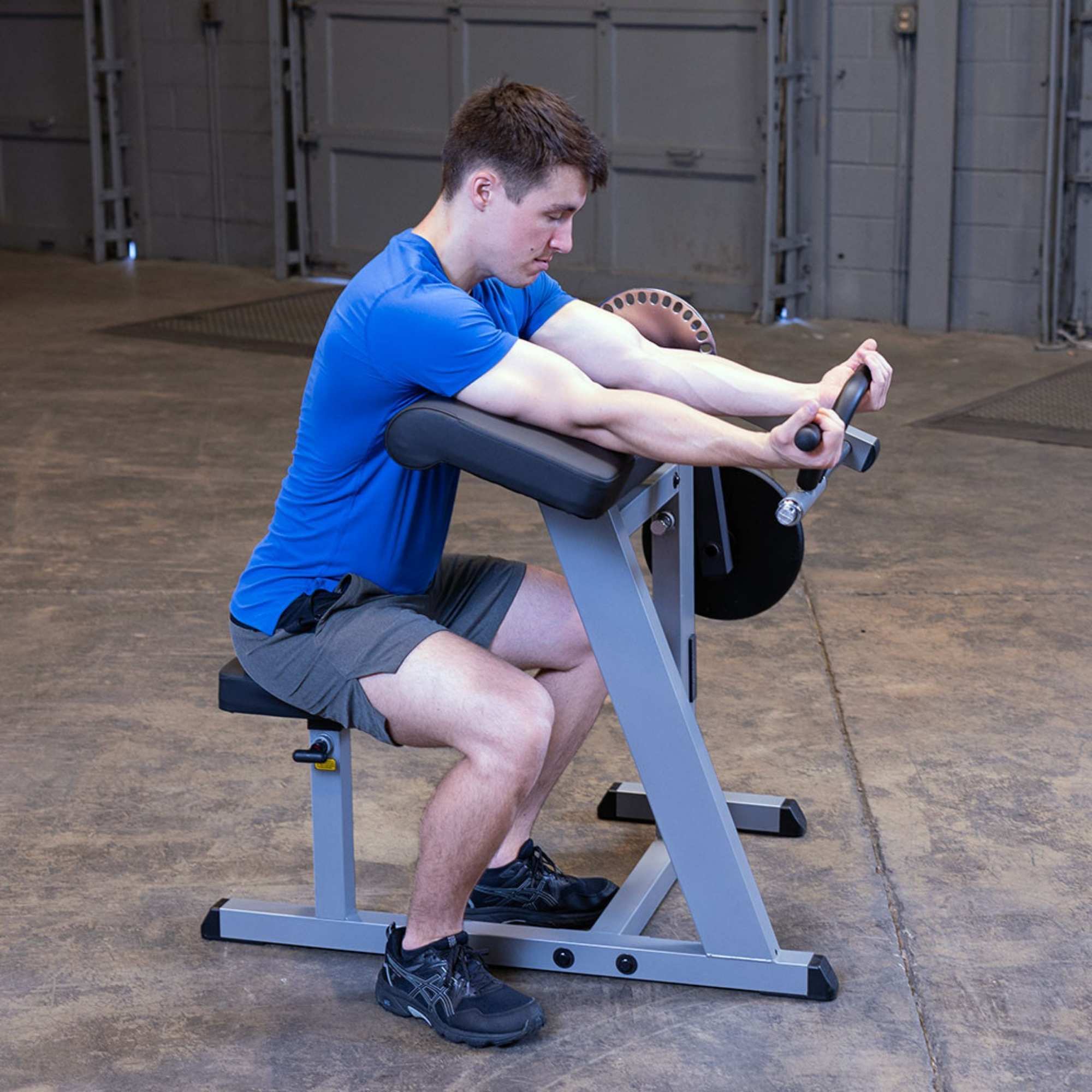 Body-Solid Cam Series Biceps & Triceps GCBT380B Man using  preacher curl bench performing bicep curls