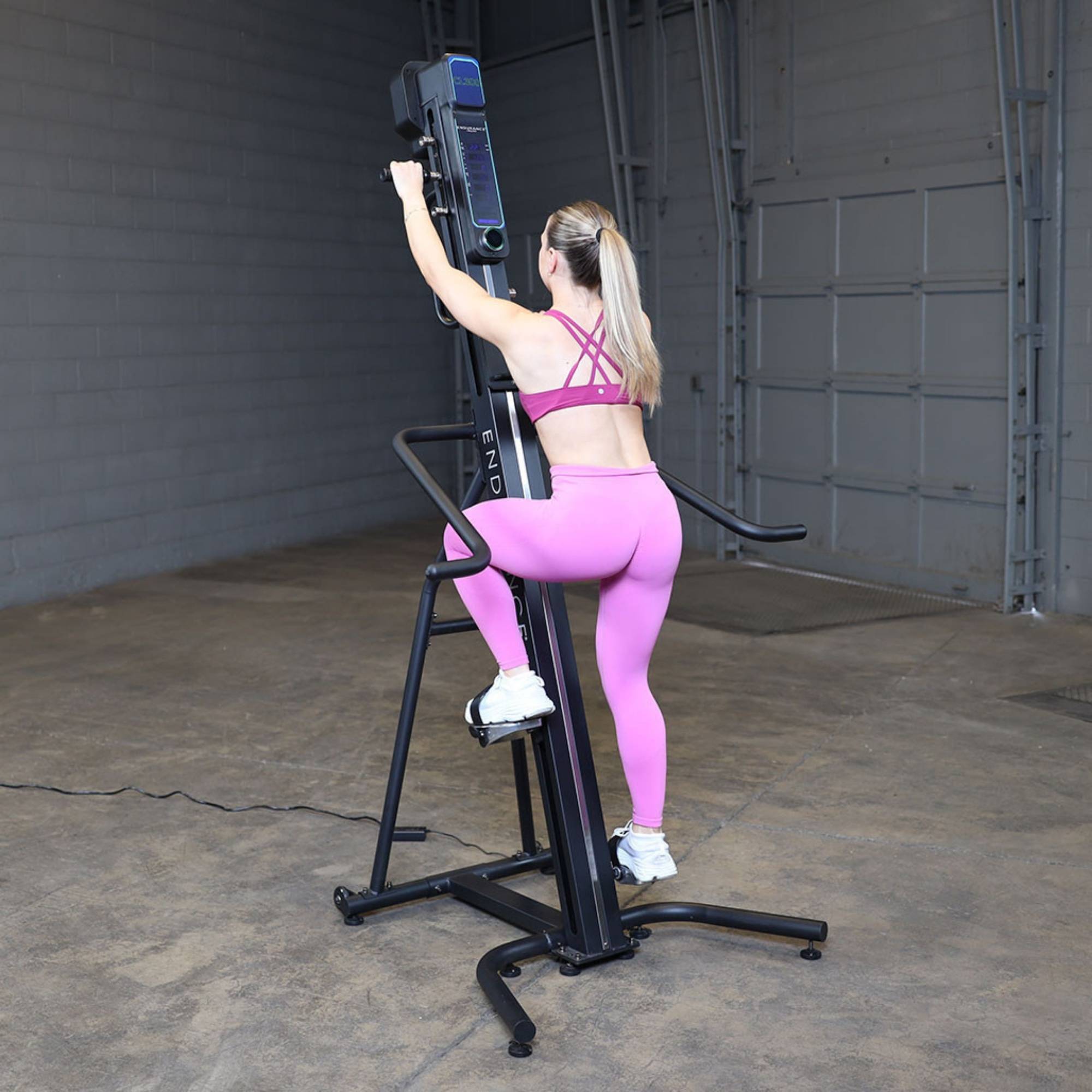 Body-Solid Climber Endurance CL300 Rear view of woman in pink gym wear starting session