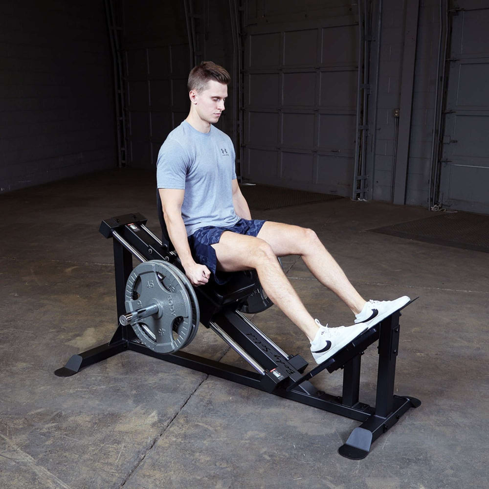Body-Solid Compact Leg Press GCLP100 Man using Body-Solid Compact Leg Press GCLP100 with weight plates