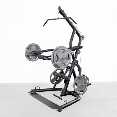 Body-Solid Corner Leverage Gym GLGS100B Multi-function gym station with adjustable bench, lat pulldown bar, and dual press arms, set on a concrete floor.
