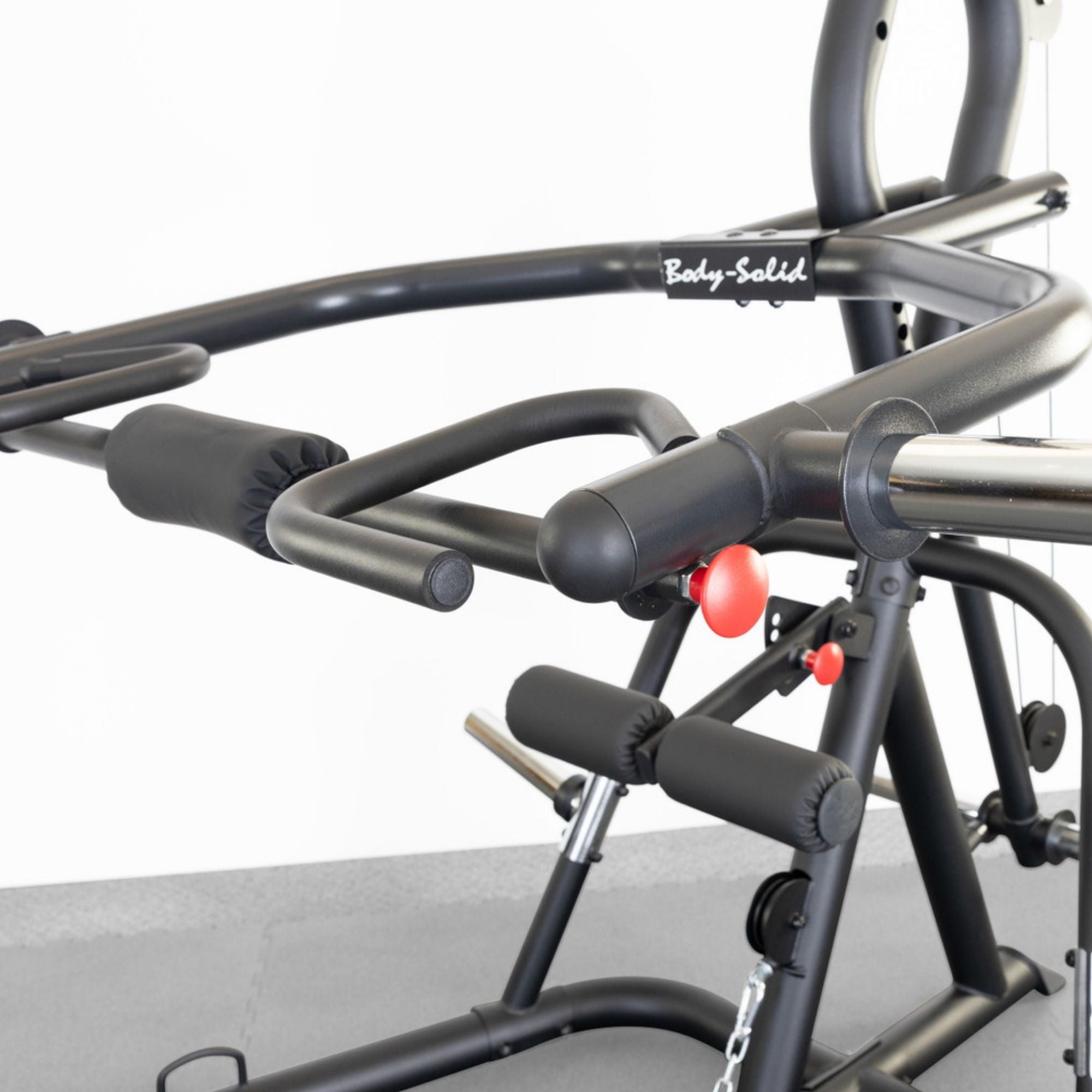 Body-Solid Corner Leverage Gym GLGS100B Detailed view of upper handles and frame with Body-Solid logo, showing padded grips and adjustable press arms.
