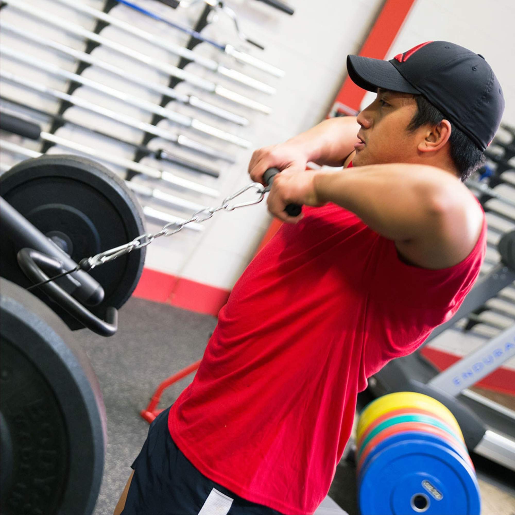 Body-Solid Corner Leverage Gym GLGS100B Man performing upright cable row exercise using a gym machine, pulling a chain handle towards chest level.

