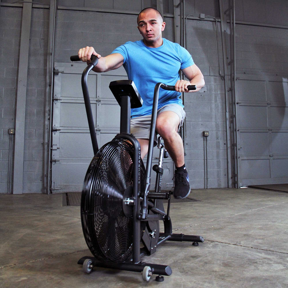 Body-Solid Endurance Dual Action Fan Bike FB300B Man pedaling and pushing on Body-Solid Endurance fan bike handles
