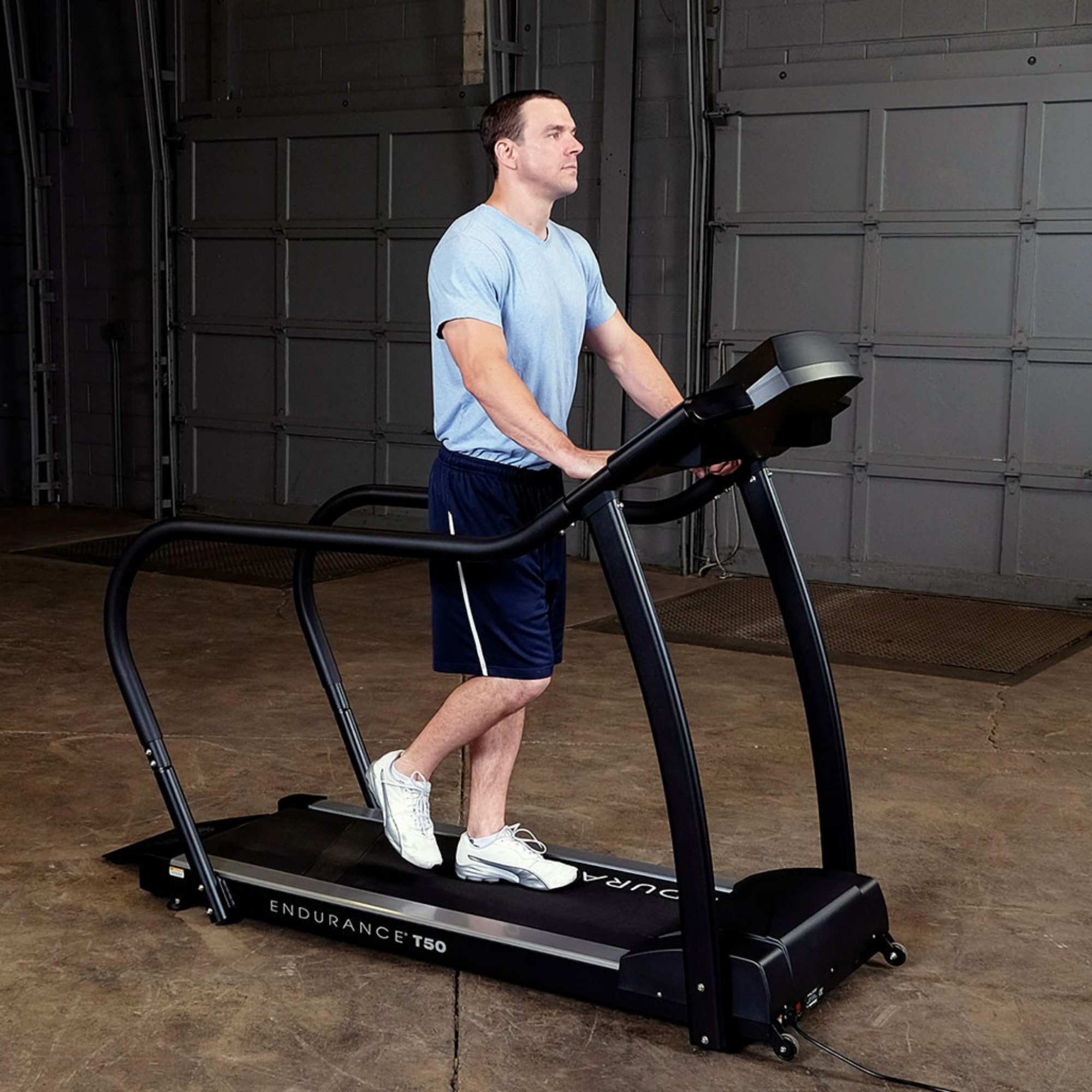 Body-Solid Endurance Walking Treadmill T50 Man walking on Endurance T50 treadmill with ergonomic handrails