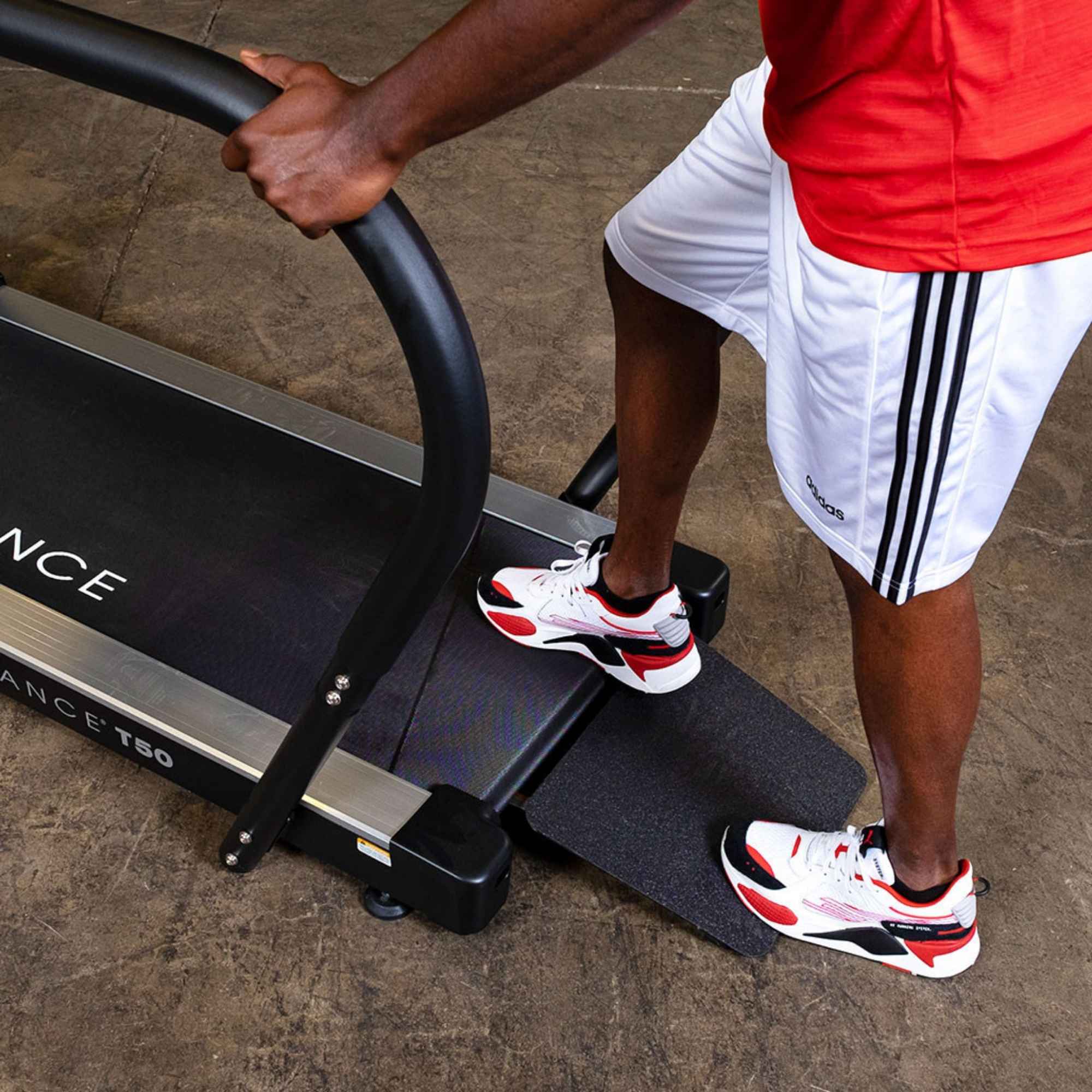 Body-Solid Endurance Walking Treadmill T50 User stepping onto Endurance T50 treadmill ramp for easy access