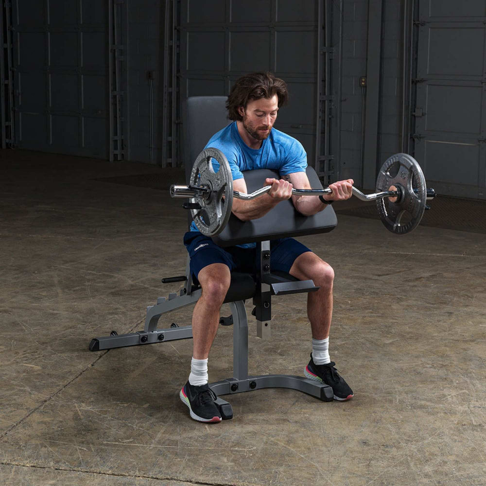 Body-Solid Flat Incline Decline Bench GFID31  Man doing barbell preacher curls using the preacher pad on a Body-Solid adjustable bench