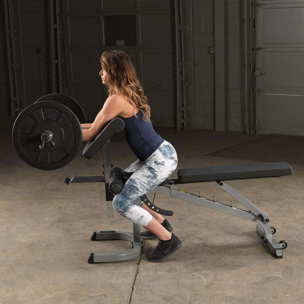 Body-Solid Flat Incline Decline Bench GFID31  Woman doing barbell preacher curls on a Body-Solid bench with preacher curl pad