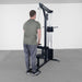 Body-Solid Lat Machine With Weight Stack GLM85B Man doing standing tricep pushdowns