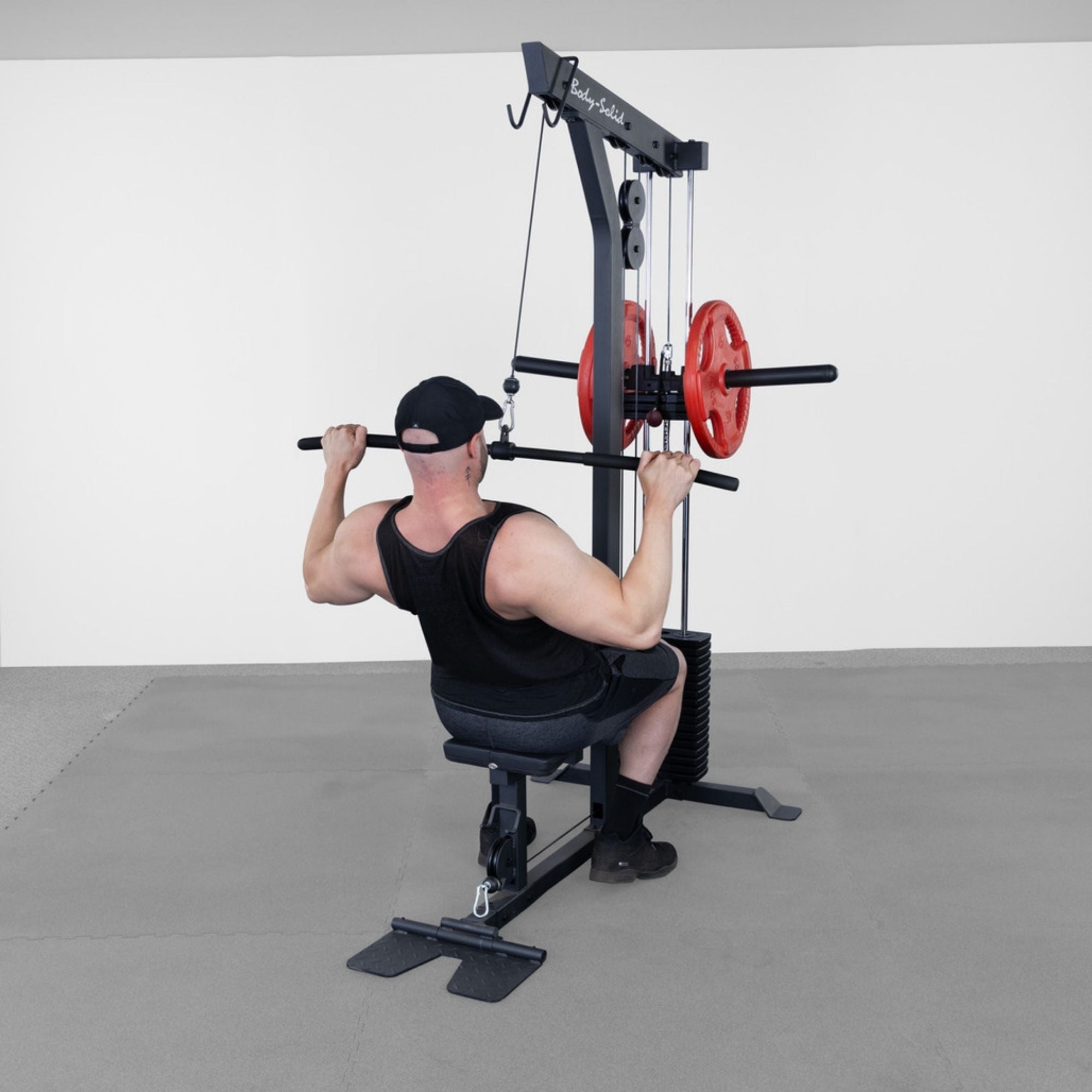 Body-Solid Lat Machine With Weight Stack GLM85B Man performing lat pulldown on lat machine with weight stack